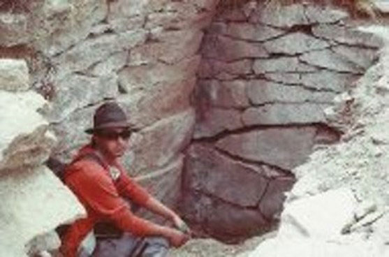 Luis Gutierrez crouched at an entrance to the Pukara Grande situated on its roof.